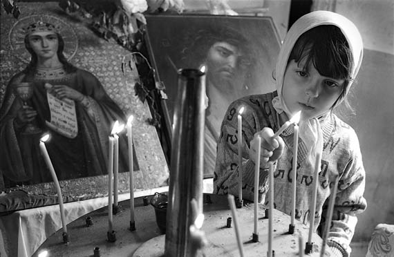 Фото Сергея Склярова. Девочка зажигает свечи в церкви