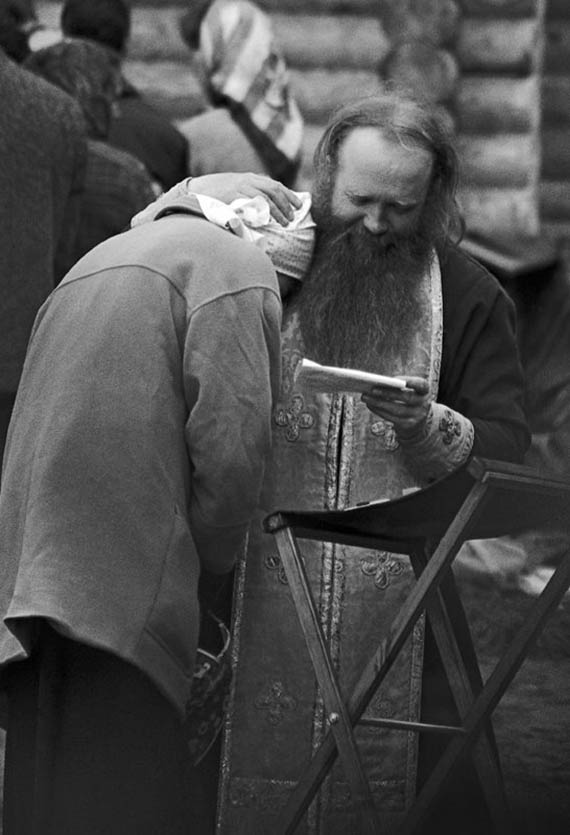 Фото Сергея Склярова. Священнослужитель обнимает женщину