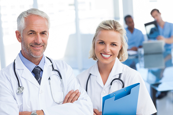Doctors holding blue file and looking at the camera