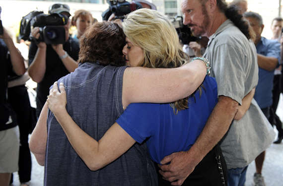 Sharon Tomlinson (centre), and a woman who cannot be identified (left), both alleged victims of serial rapist Robert Fardon hug outside the Supreme Court in Brisbane, Friday, Sept. 27, 2013. Robert John Fardon, 63, who has been serving an indefinite sentence for sex offences, is to be released from jail into the community, under supervision. (AAP Image/Dan Peled) NO ARCHIVING