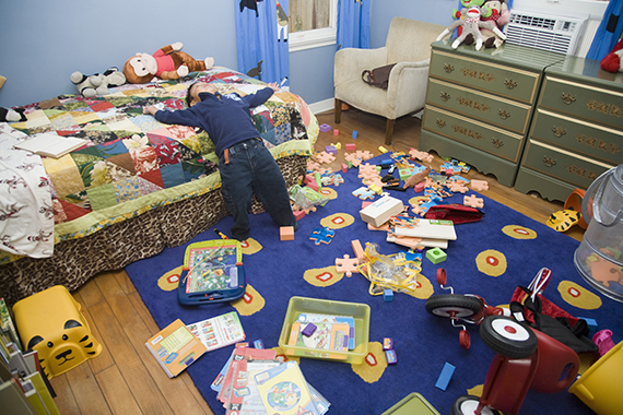 Asian boy in messy bedroom