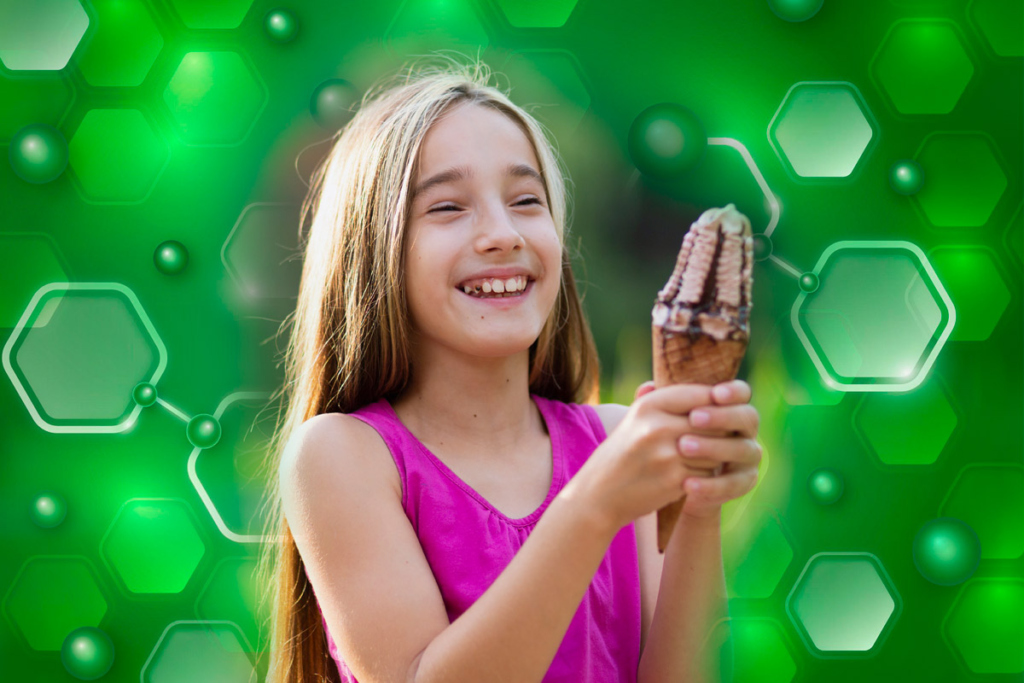 Счастливая девочка держит мороженое в руках