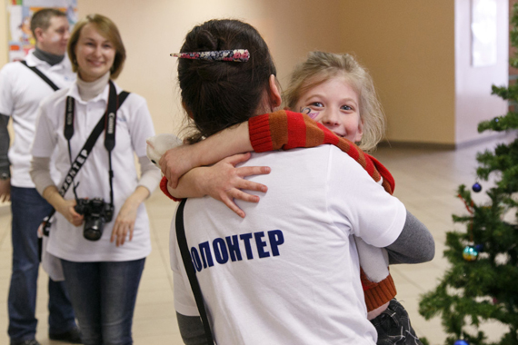 Волонтер обнимает девочку