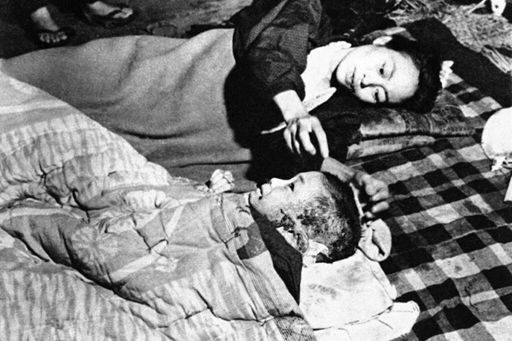 Пострадавшие от бомбардировки женщина и ее ребенок лежат на одеяле в поврежденном здании банка, превращенном в госпиталь. 6 октября 1945 года. Фото AP Photo/ ТАСС