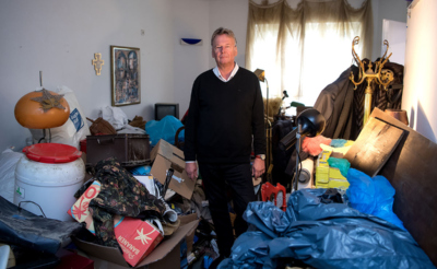 мужчина стоит в захламленной квартире
