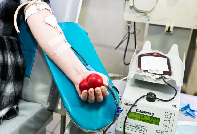 Потенциальный донор костного мозга во время сдачи крови для получения уникальньного генетического кода, позволяющего войти в Национальный регистр доноров костного мозга