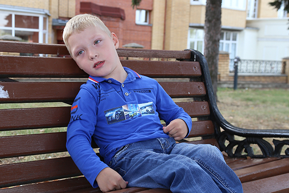 Мальчик с ДЦП сидит на скамейке