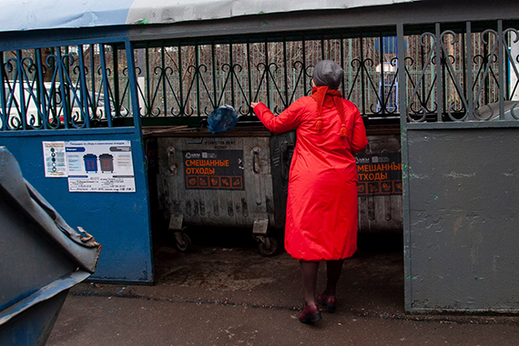 Женщина выбрасывает мусор в контейнер "смешанные отходы"
