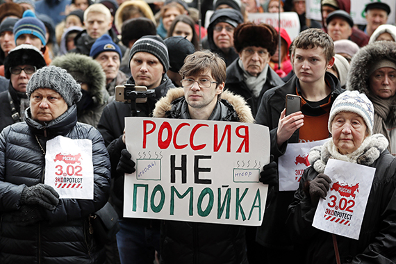 Участники общенациональной акции протеста держат плакат с надписью «Россия — не свалка» перед префектурой Центрального округа в Москве