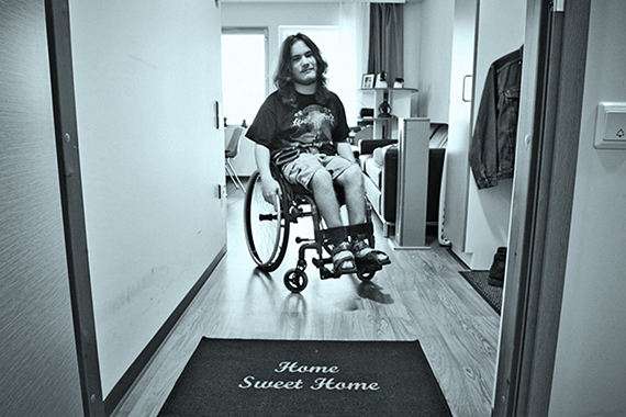 Мужчина в инвалидном кресле в квартире