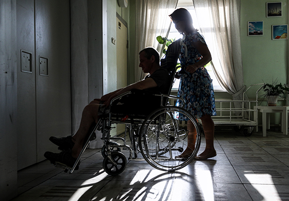 Волонтер с пациентом в инвалидной коляске