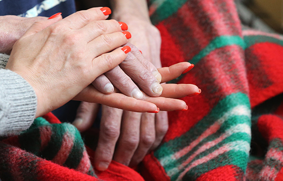Руки молодой женщины держат руку бабушки