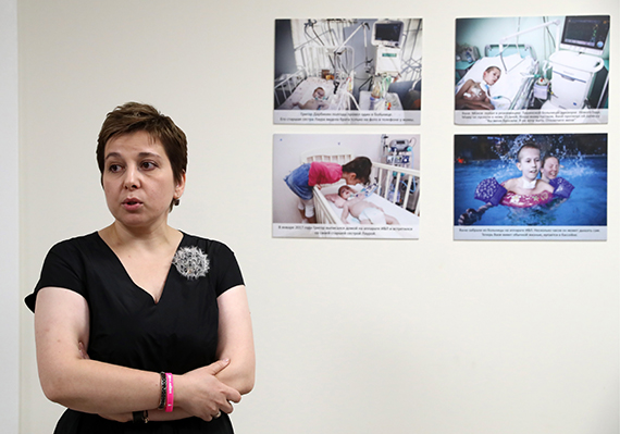Нюта Федермессер на фоне стены с фотографиями неизлечимо больных детей