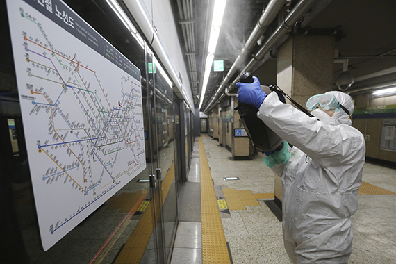 Работник в защитном костюме дезинфицирует станцию метро в Сеуле из-за вспышки коронавируса