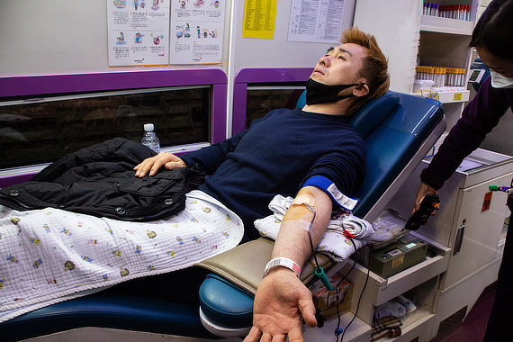 Мужчина лежит в кресле во время сдачи крови для переливания