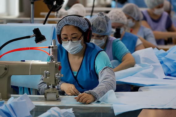 Работники шьют одноразовую медицинскую одежду