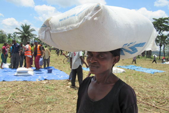 Конголезская женщина переносит на голове мешок 