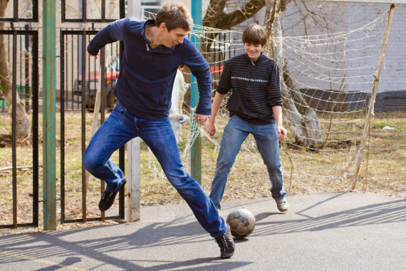 Молодые люди играются с футбольным мячом