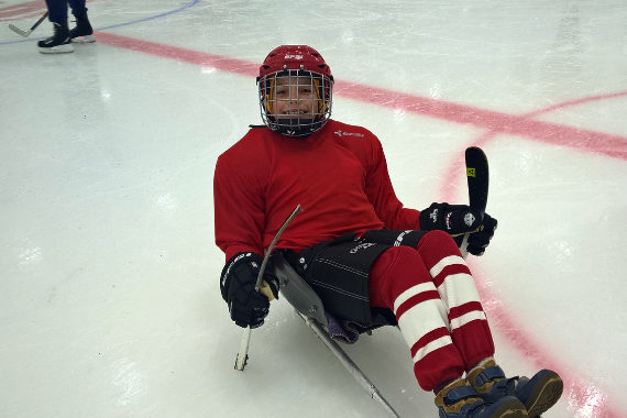 Мальчик сидит на хоккейном льду