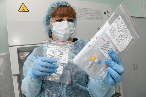 Медицинский работник держит набор реагентов для выявления РНК коронавируса