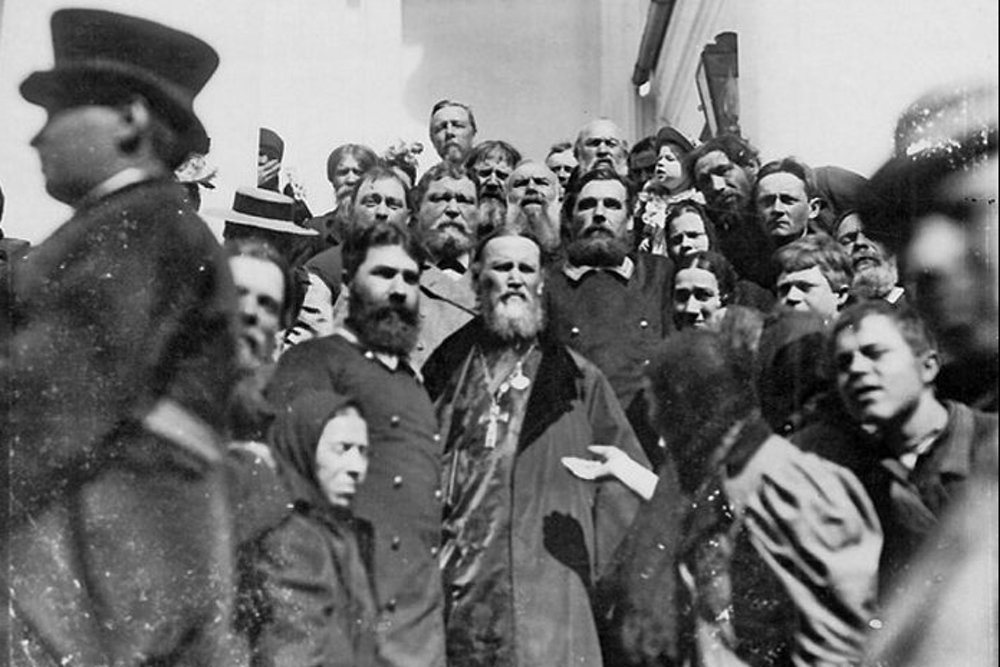 Святой праведный Иоанн Кронштадтский в окружении народа. Фото с сайта rg.ru