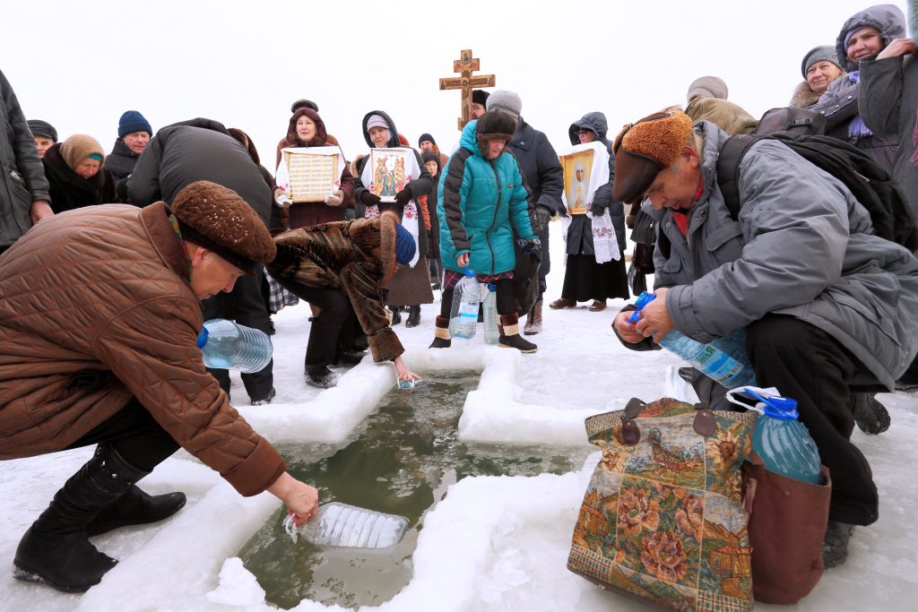 Люди набирают крещенскую воду в проруби на реке Тобол, г. Курган