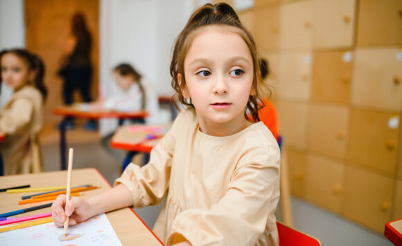 В классе девочка ведет запись во время урока