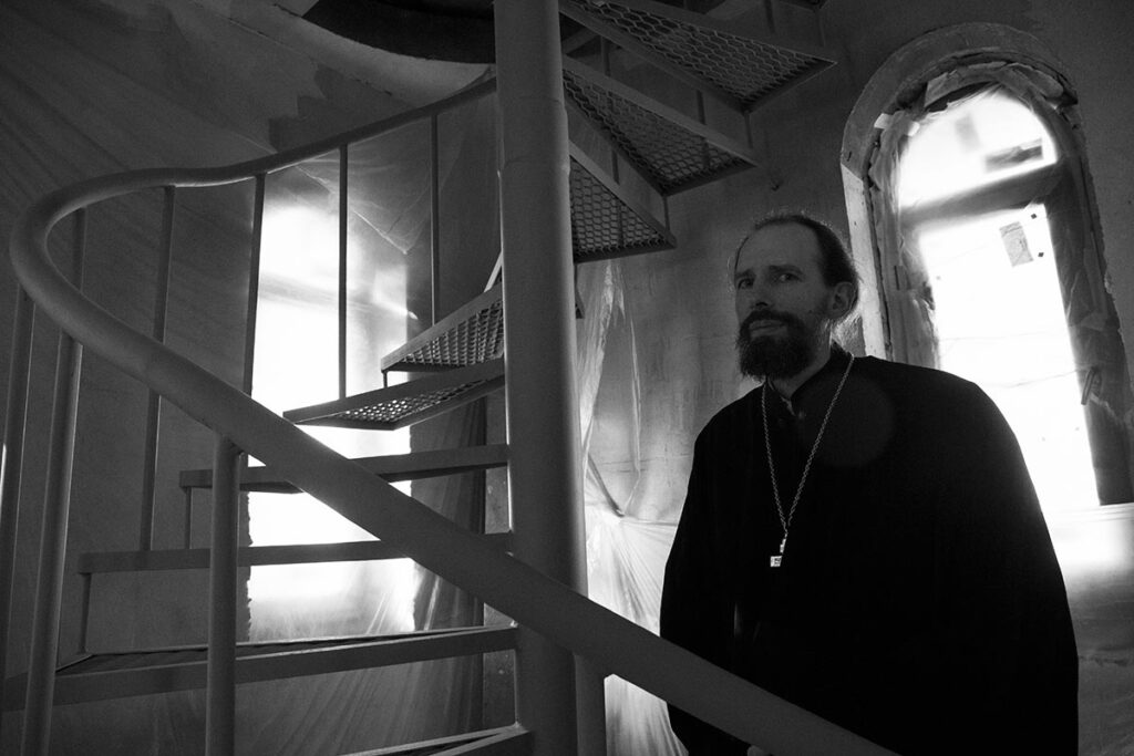 Священник Кирилл Марковский у винтовой лестницы в реставрируемом храме
