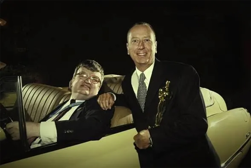 Сценарист «Человека дождя» Барри Морроу держит в руке статуэтку «Оскар», Ким Пик сидит в Buick Roadmaster 1949 года выпуска