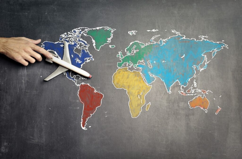Карта мира, нарисованная мелом на доске с игрушечным самолетом