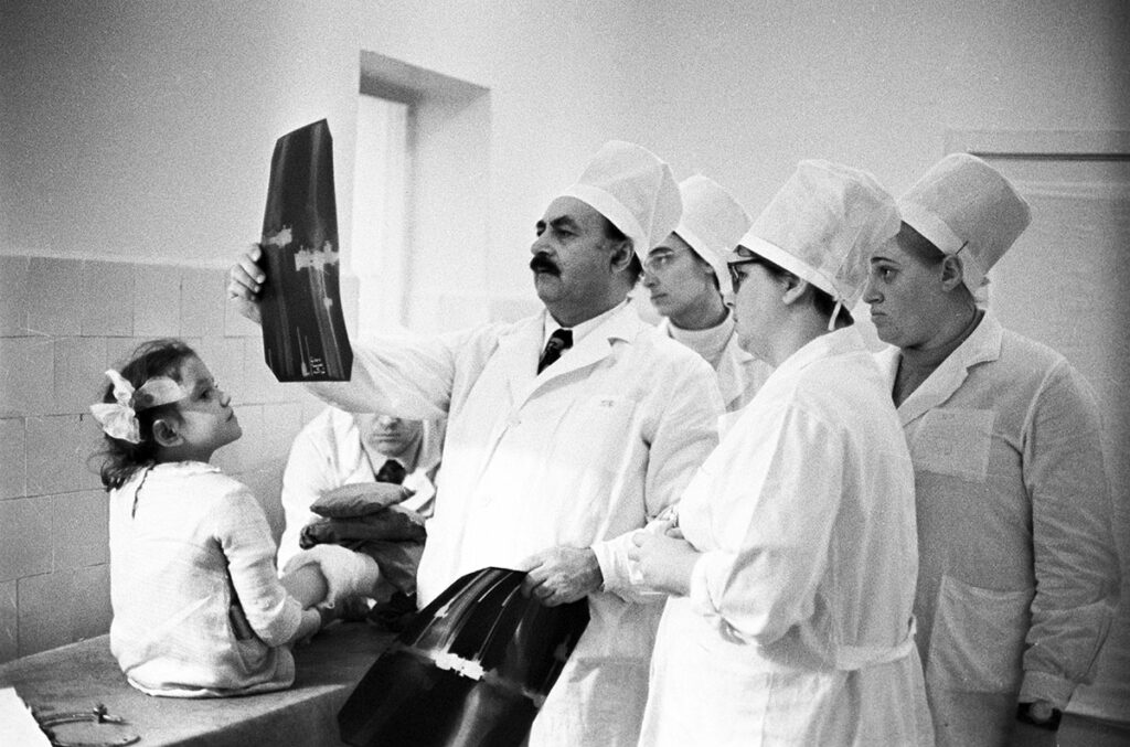 Хирург-ортопед Гавриил Илизаров с коллегами медиками осматривает пациентку – маленькую девочку. Смотрят ее рентгеновские снимки