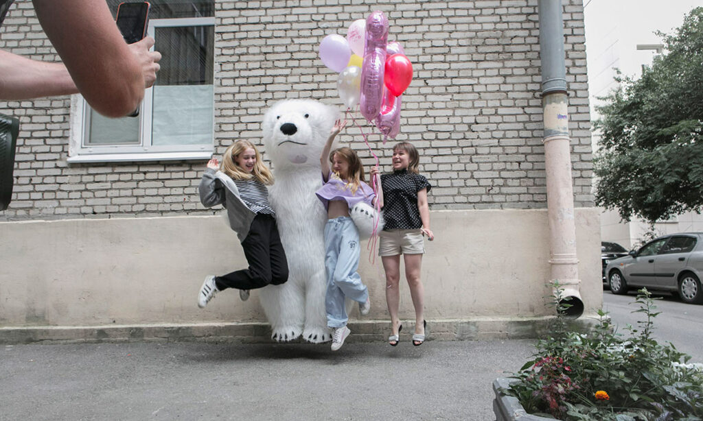 Подростки прыгают вместе с белым медведем