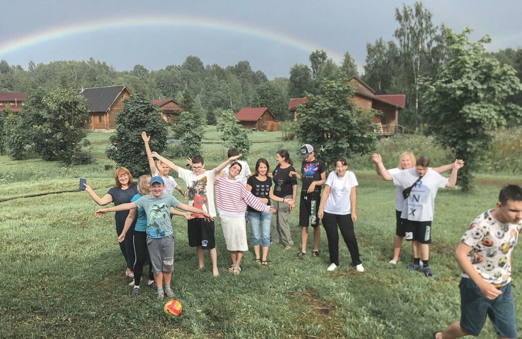 Родители и дети на поляне, на небе радуга