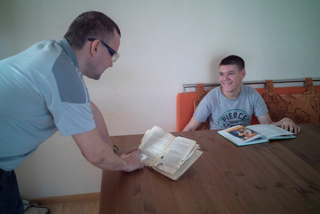 Дмитрий с Артемом за столом с книгами