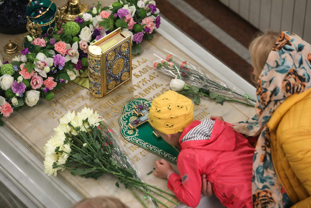 Женщина с девочкой в часовне святой блаженной Ксении Петербургской на Смоленском кладбище