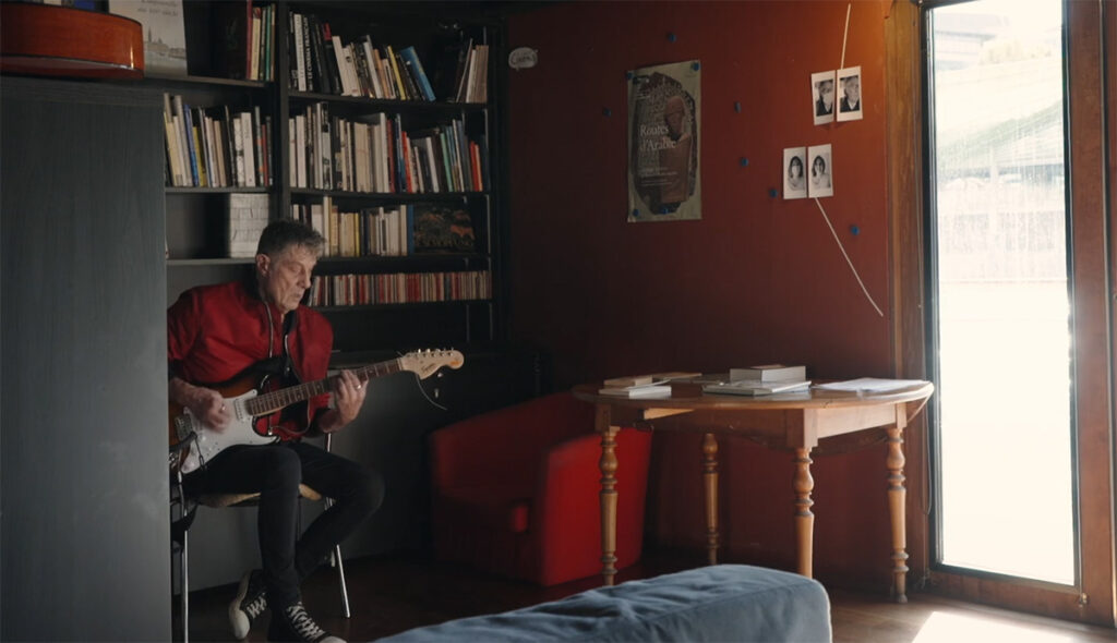 Кадр из фильма «На Адаманте». Мужчина играет на гитаре