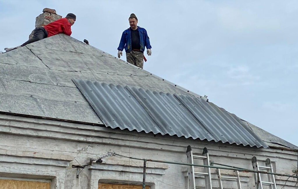 Строители-волонтеры ремонтируют крышу дома