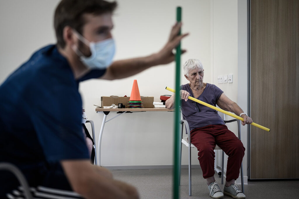 Волонтер проводит занятие по физкультуре с пациентами с болезнью Альцгеймера