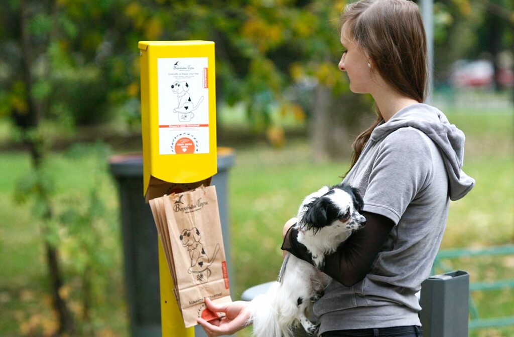 Девушка держит специальный пакет для сбора собачьих экскрементов