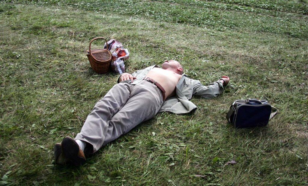Пьяный мужчина спит на газоне