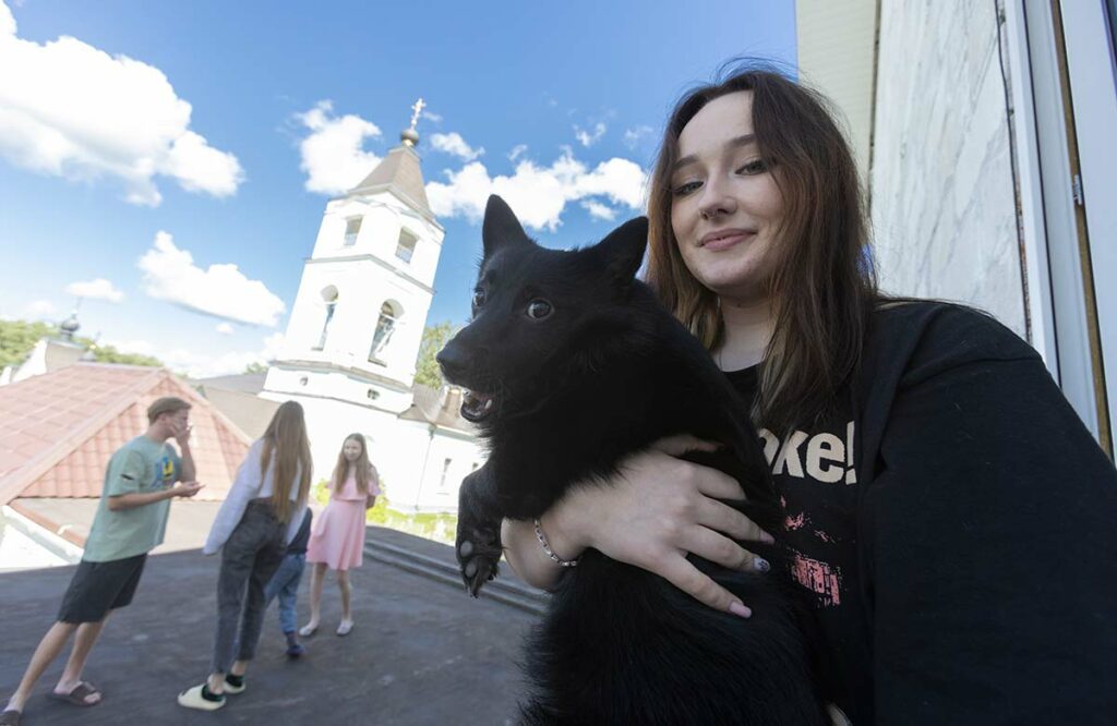 Аня с собакой на фоне храма