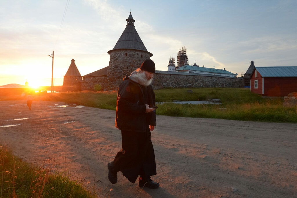 Соловецкий ставропигиальный мужской монастырь. Монах на фоне монастыря