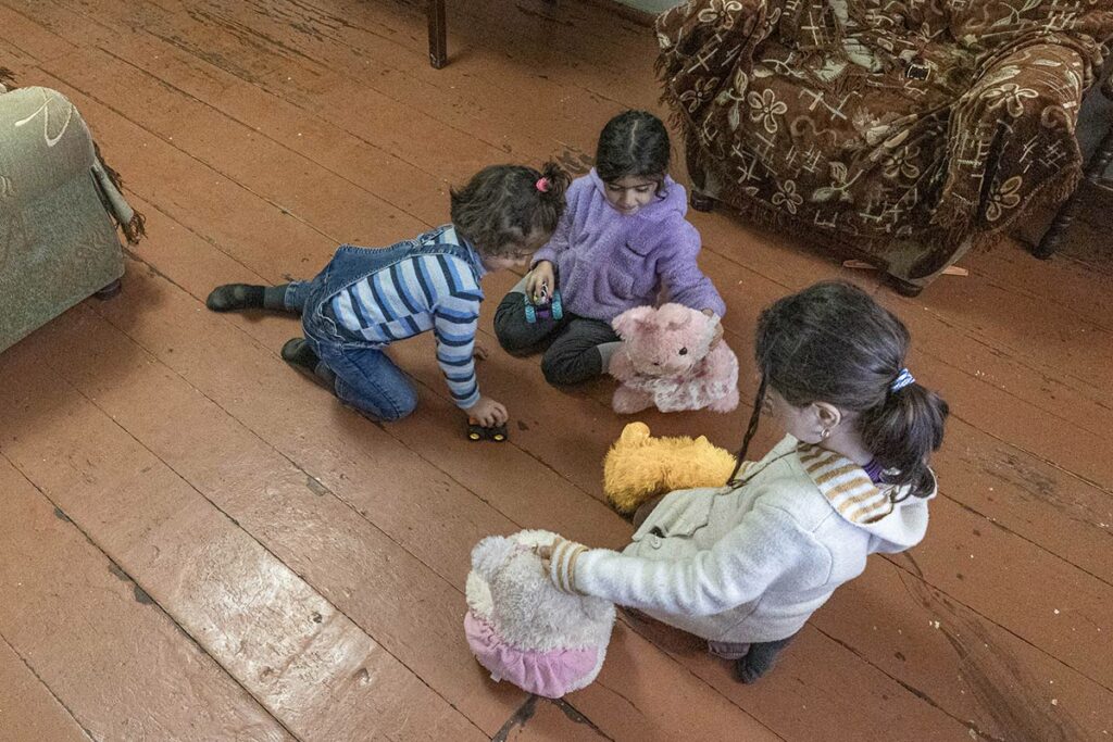 Три девочки, дочери Виктории, играют на полу в игрушки