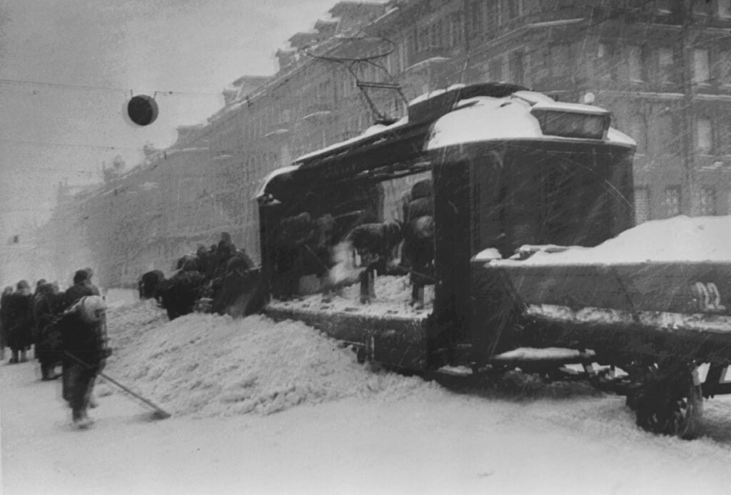 Погрузка сколотого льда на грузовой трамвай во время уборки снега на проспекте 25 Октября в блокадном Ленинграде. 11 марта 1942 года. Фото Георгий Коновалов/ТАСС