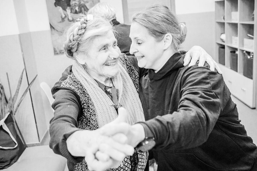Пожилая женщина и социальный работник танцуют