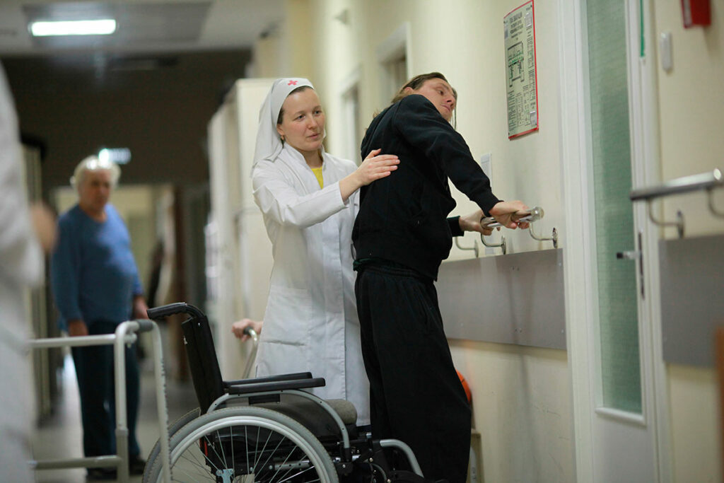 Патронажная сестра помогает больному в больнице святителя Алексия. 2013 год