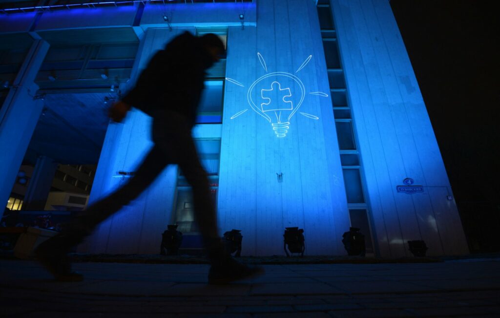 Логотип акции Light it Up Blue на здании в Москве