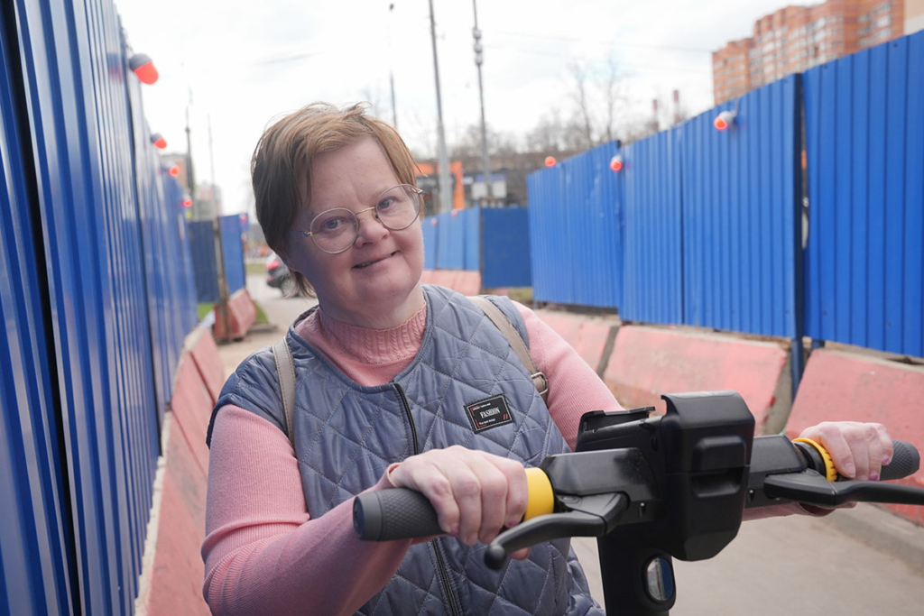 Женщина с синдромом Дауна на самокате