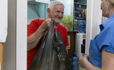 Пожилой мужчина с пакетом продуктов