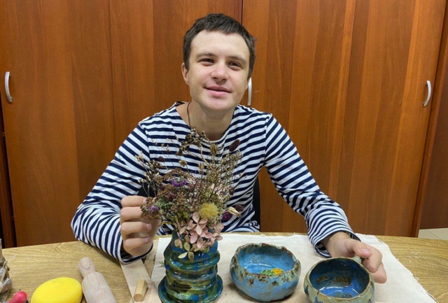 молодой человек за рабочим столом в мастерской